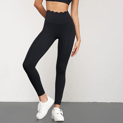One-shoulder yoga bra with scalloped edges, elegantly styled in a solid color, paired with matching leggings.
