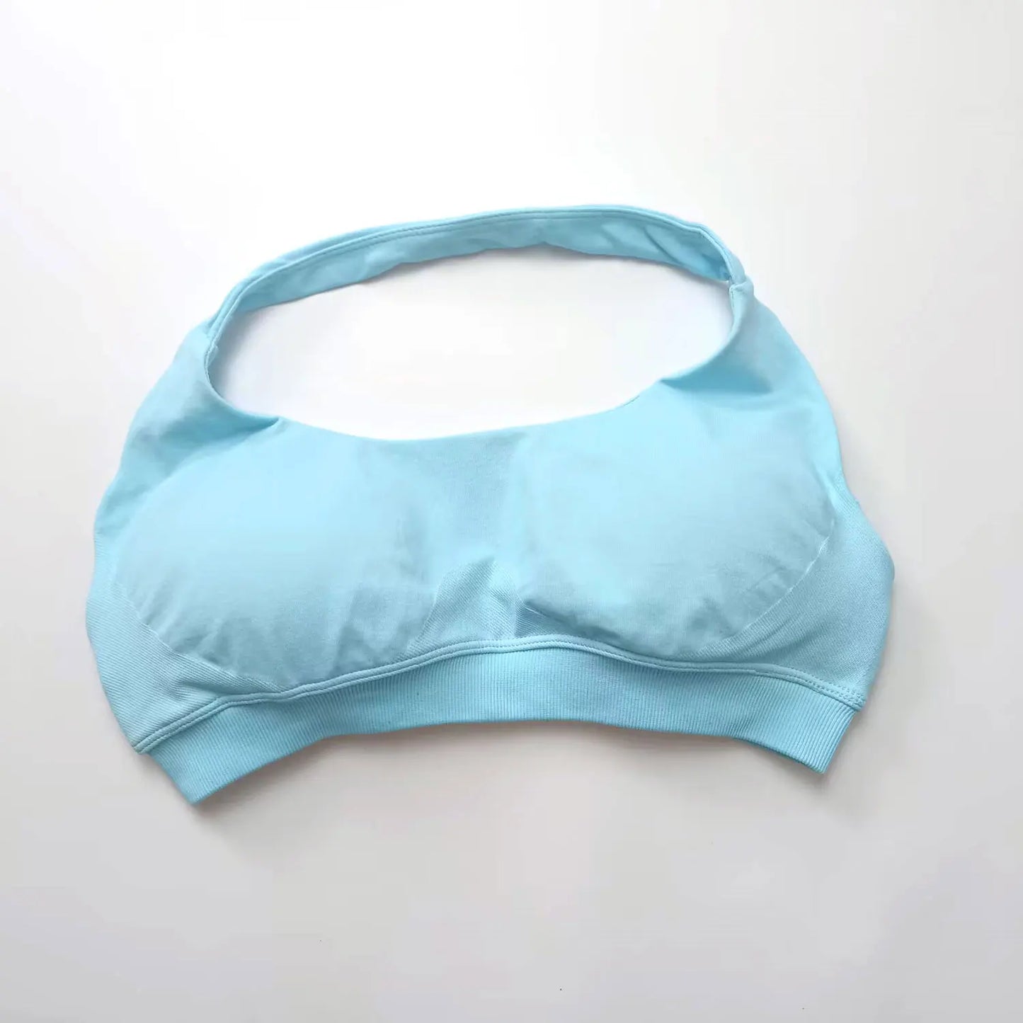 Light blue seamless halter sports bra featuring an open-back design and thin straps for elegant support during workouts.