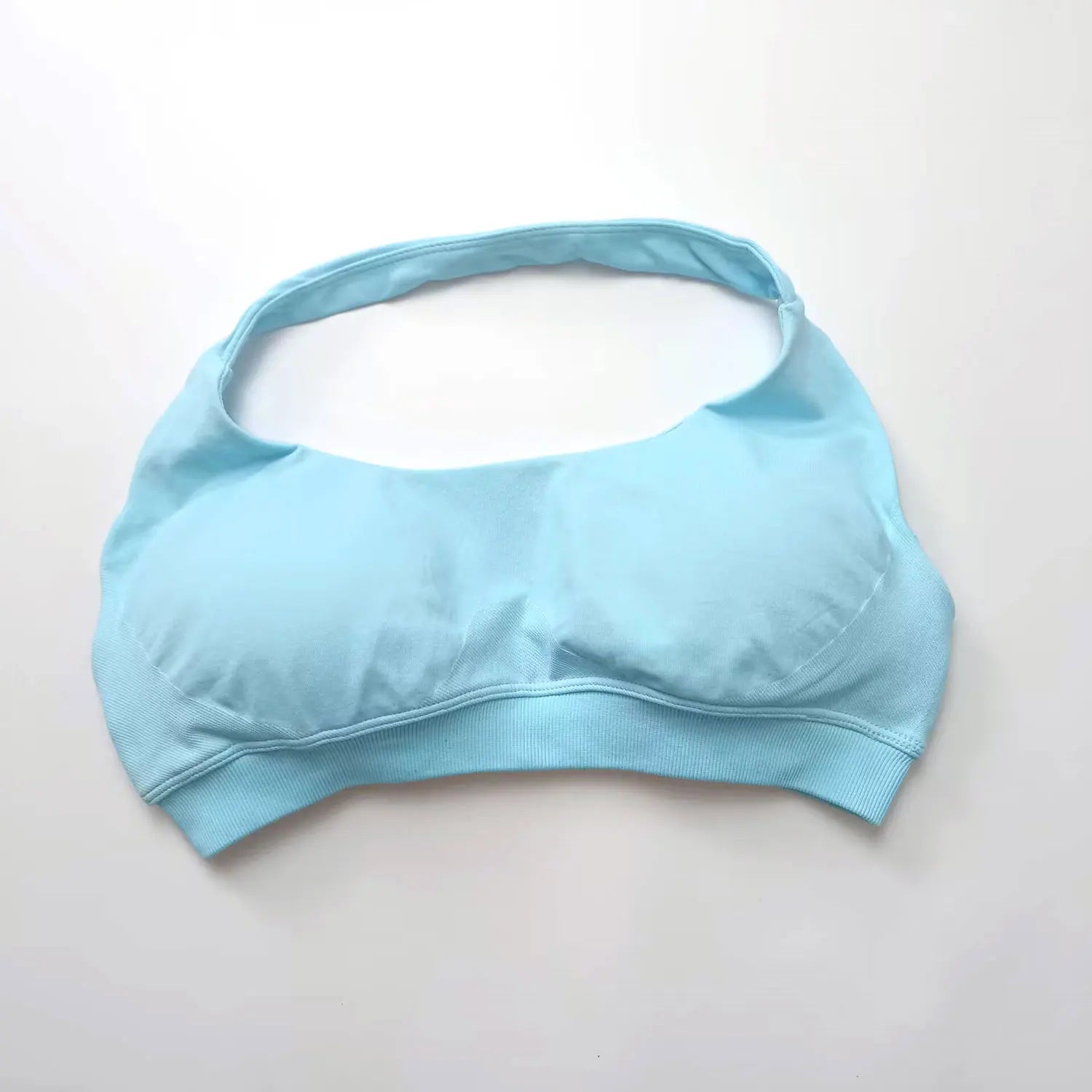 Light blue seamless halter sports bra featuring an open-back design and thin straps for elegant support during workouts.
