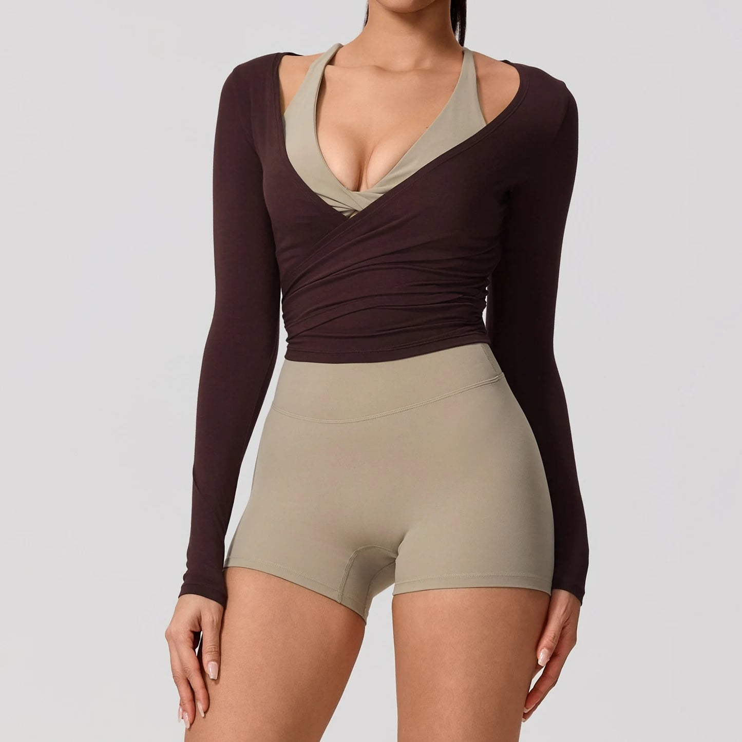 Long sleeve Hearuisavy yoga shirt in a chic wrap style with a flattering V-neckline, paired with light shorts.