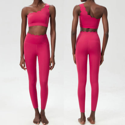 Vibrant pink two-piece fitness yoga set featuring a one-shoulder top with scalloped edges and form-fitting leggings.