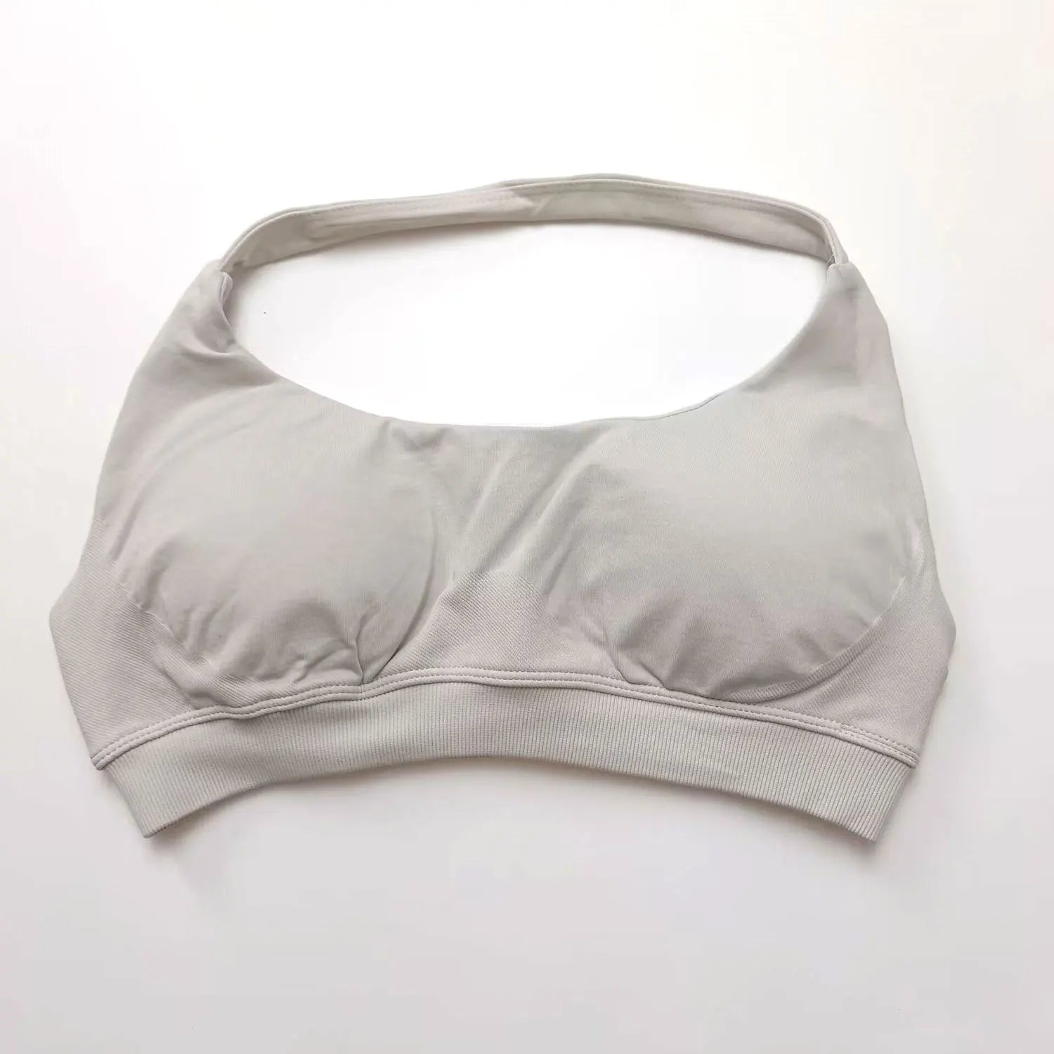 Seamless halter sports bra in a light color featuring an open-back design and molded push-up cups for elegant support.
