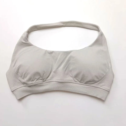 Seamless halter sports bra in a light color featuring an open-back design and molded push-up cups for elegant support.