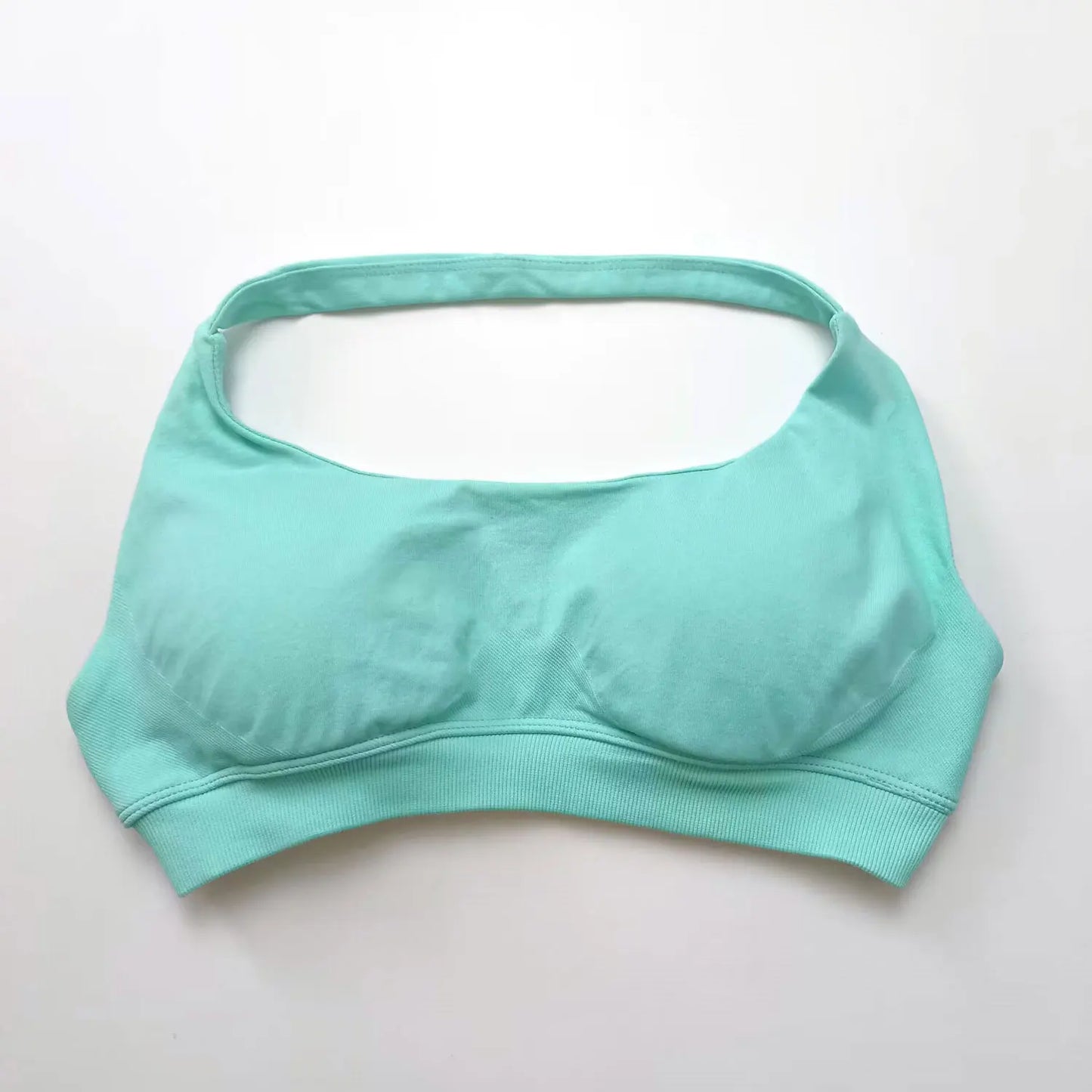 Light mint seamless halter sports bra featuring an open-back design and high-support push-up style, perfect for workouts.