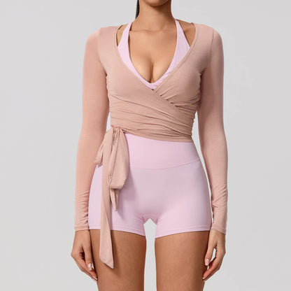 Light pink long sleeve wrap yoga shirt with a flattering V-neckline, perfect for stylish activewear.