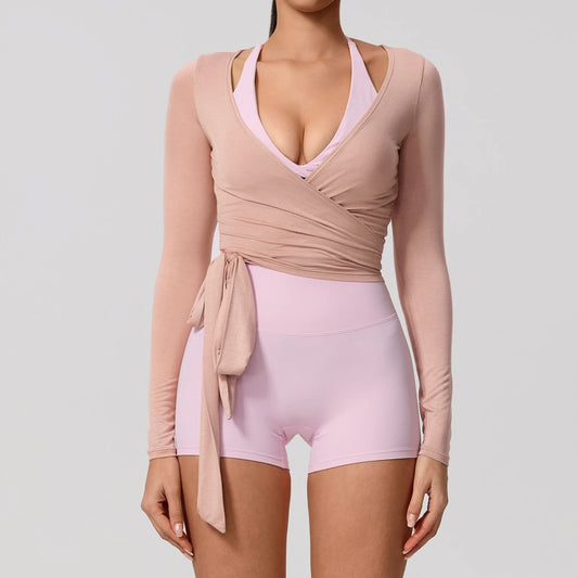 Light pink long sleeve wrap yoga shirt with a flattering V-neckline, perfect for stylish activewear.