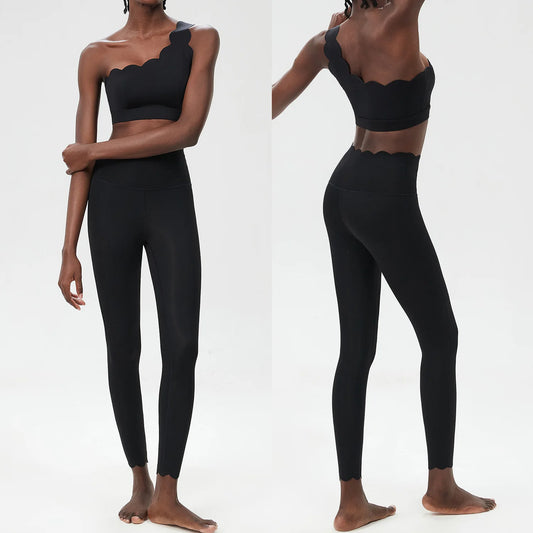 Stylish black two-piece yoga set featuring a scalloped cropped top and high-waisted leggings, designed for effortless movement.