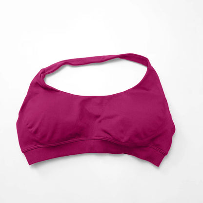 Seamless magenta women's sports bra with a halter neck design and open back, perfect for high-support workouts.